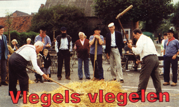 Pastoor Vermoesen en Jef De Bruyne geven een demonstratie vlegeldorsen